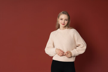 Portrait of young attractive blonde asian woman on red background copy space