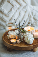 Cozy corner for home meditation and relaxation. Decor for apartment, house, indoors design. Aroma diffuser, burning scented candles, spring aromatherapy with blooming hyacinth floral scent