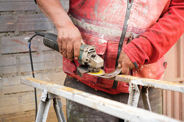 latin man's hands working with grinder cutting metal in latin america, bolivia - work concept
