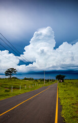 Road and a beautiful rain cloud in the background, vertical photo