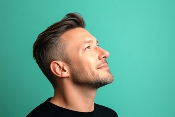 Fototapeta premium Visual idea of style for aging men. A fashionable midlife male standing confidently. Green solid background. Modish men's undercut haircut - midlife white man with hair.