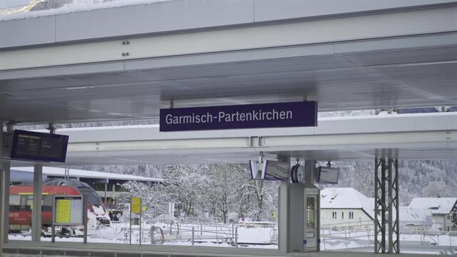 Scenic train journey through snowy Bavarian Alps. Garmisch-Partenkirchen station connects regional and long-distance trains, offering travelers stunning mountain views and true winter vibes. Bahnhof. 