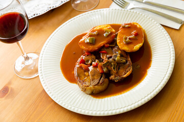 Image of tasty lamb meat baked and served with sauce and potatoes at plate
