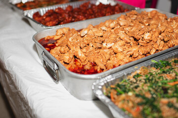Trays of Korean dishes at a catered buffet setup at gathering 