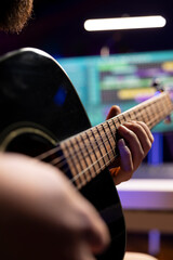 Skilled producer recording his song on guitar to mix and master music on daw software, working with...
