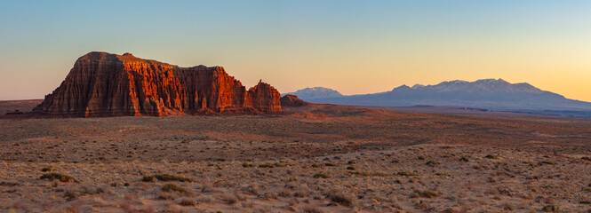 Woodpecker Butte glows in the warm last light during a beautiful winter sunset.  The snow covered Henry Mountains rise above this desert landscape near Hanksville Utah.