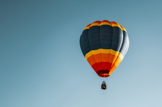Bal&atilde;o de Ar Quente com Cores Vibrantes Voando em C&eacute;u Azul