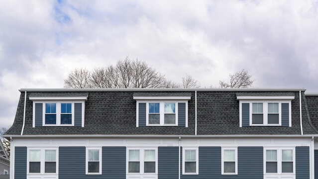 Elegant blue-gray residential building with mansard roof and dormer windows in Brighton, Massachusetts, USA
