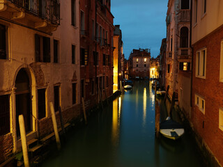Long exposure evening photo of canal in Venice with buildings and moored boats. Venice, Italy.