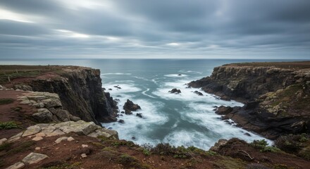 Fototapeta premium Coastal cliffs and sea under a cloudy sky showcasing the power and beauty of nature.