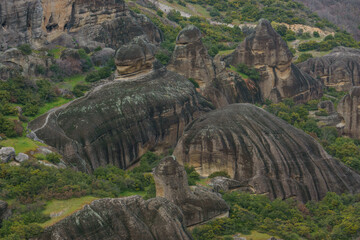 Detail view of landscape with eroded rocks of Meteora rock formations with green grass at spring time, Kalambaka, Thessaly, Greece