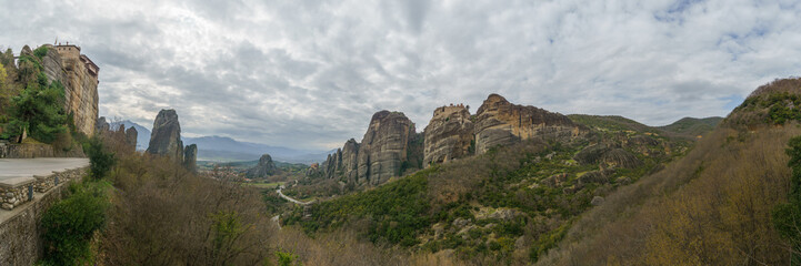 Panoramic view of Meteora with Roussanou, Agios Nikolaos and Varlaam Monasteries on top of rocks and cloudy sky, Kalambaka, Thessaly, Greece
