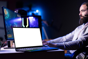 Isolated screen laptop next to man using gaming keyboard to play spaceship flying singleplayer...