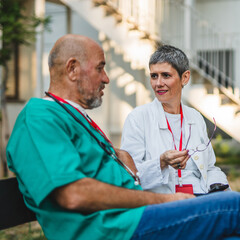 medical workers man and woman sit on bench enjoy on coffee break
