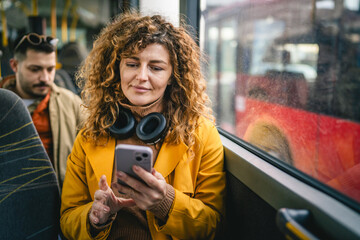 young adult woman use public transport, sit with phone and headphones