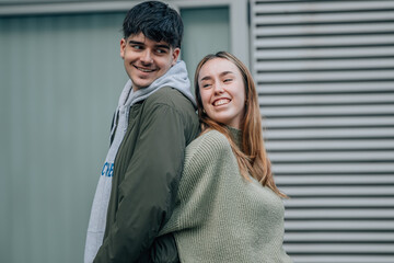 couple in love hugging on the street with their backs to each other