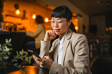 Japanese businesswoman use mobile phone for research or fun on work