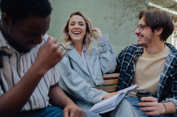 University students laughing together on bench