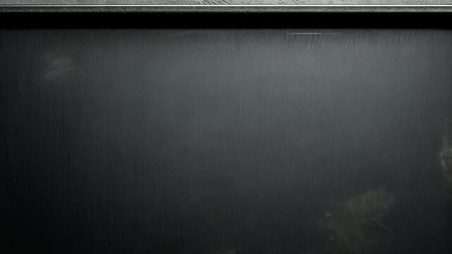 Dark baking sheet rotates gradually against a moody, textured gray surface