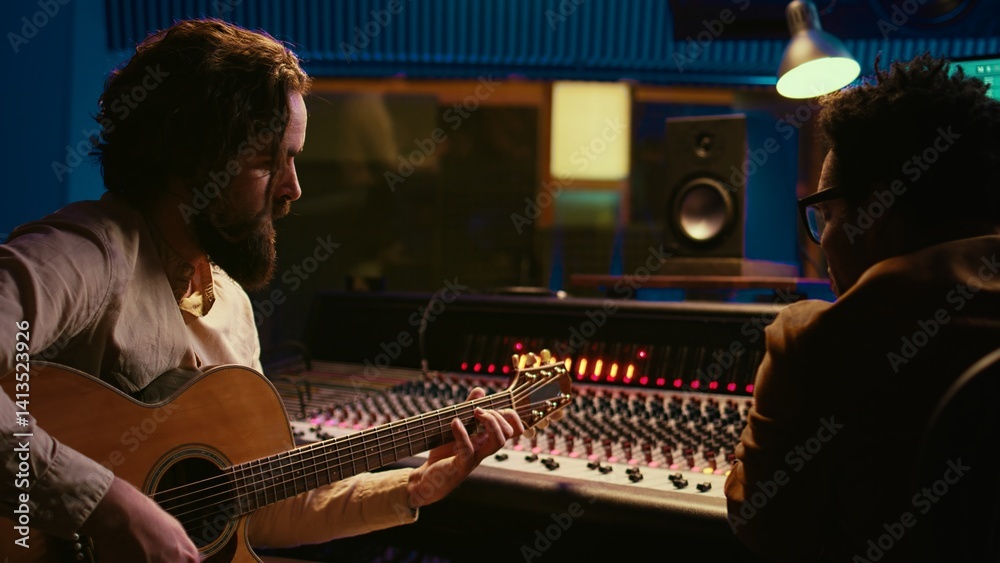 Poster songwriter composing a song with sound engineer in professional studio, recording session with his e