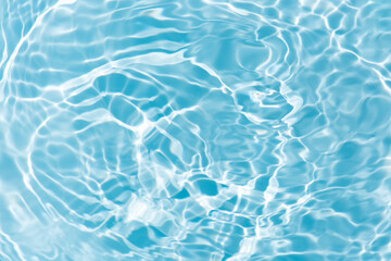 Blue water with ripples on the surface. Defocus blurred transparent blue colored clear calm water surface texture with splashes and bubbles. Water waves with shining pattern texture background.