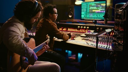 Talented guitarist doing live performance in professional studio, recording new tracks on mixing...