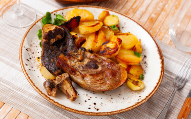 Delicious roasted leg of lamb with potatoes served on platter..