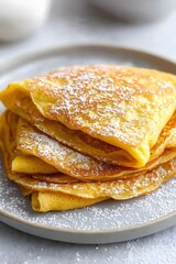 Delicious Golden Crepes Stacked High with Powdered Sugar