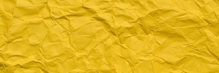 A textured yellow crumpled paper background with natural creases and folds. Ideal for design projects, digital graphics, or creative presentations requiring a vibrant, Long banner