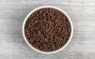 Overhead View of Dark Brown Granules in White Bowl