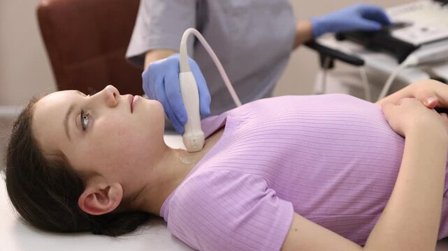 Girl undergoing thyroid gland ultrasound examination in clinic