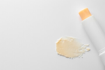 Stick of lip balm and sample on white background, top view. Space for text