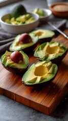 Fresh ripe avocados halved on a wooden board, showing vibrant green flesh.