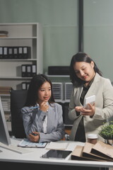 Asian Businesswoman Using laptop computer and working at office with calculator document on desk, doing planning analyzing the financial report, business plan investment, finance analysis concept.