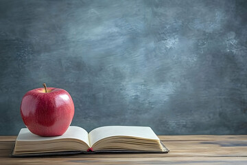 Red apple and open book on wooden desk, classic symbol of learning.