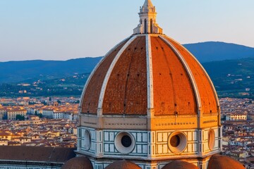 Obraz premium A sunset view of Florenceâ€™s Cathedral dome (Duomo di Firenze), glowing in warm orange light