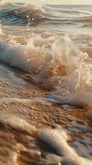 Foamy waves gently crashing on a sandy shoreline.