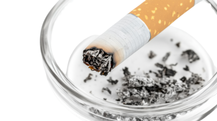 Smoking hazard: A close-up shot of a lit cigarette, resting in a glass ashtray filled with ash, highlighting the unhealthy consequences and dangers of smoking.