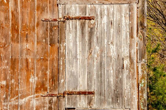 USA, New Hampshire, Troy. Old barn door with rusted strap hinge.