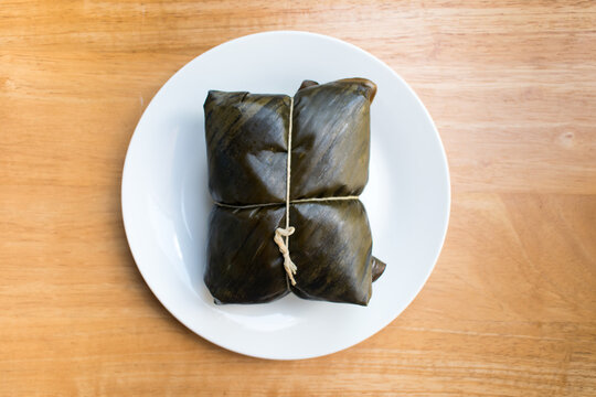 Whole traditional Nicaraguan nacatamal wrapped in banana leaf, authentic corn dough tamale popular in Central American cuisine.