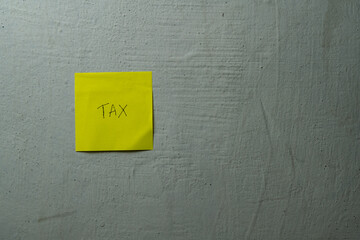 Simple Yellow Adhesive Note Displays Important Financial Tax Obligation Reminder