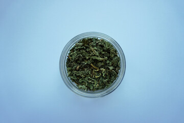 Dry Green Herbs in Glass Jar Against Clean Background Simple Still Life