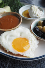 Delicious breakfast with fried egg, olives, and sweet toppings