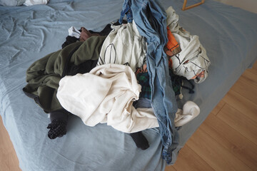 Clothes piled on bed after laundry day at home