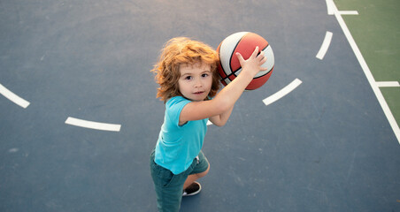 Kid with basketball ball. Cute smiling boy plays basketball. Active kids play basketball, Top view....