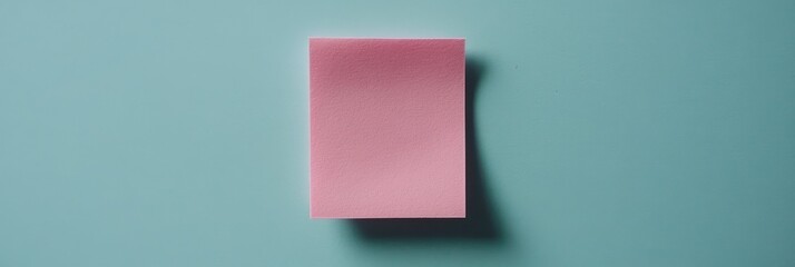 Pink sticky note on a teal background