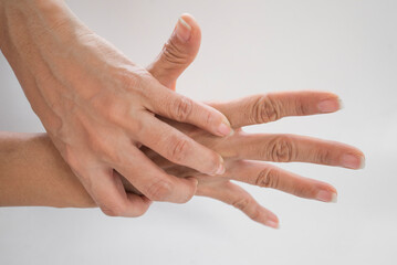 Close-up of man's hands holding each other against white background