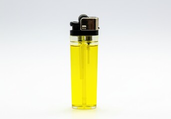 A clear yellow lighter with black and silver components on a white background in a studio shot