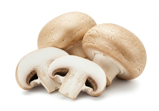 A close up of several brown mushrooms with two of them sliced on a white background view