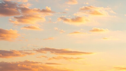 Obraz premium Vibrant Sky Canvas: Soft Orange and Yellow Clouds Gently Fill a Pale Blue Expanse, Creating a Warm and Tranquil Scene at Sunset or Sunrise.